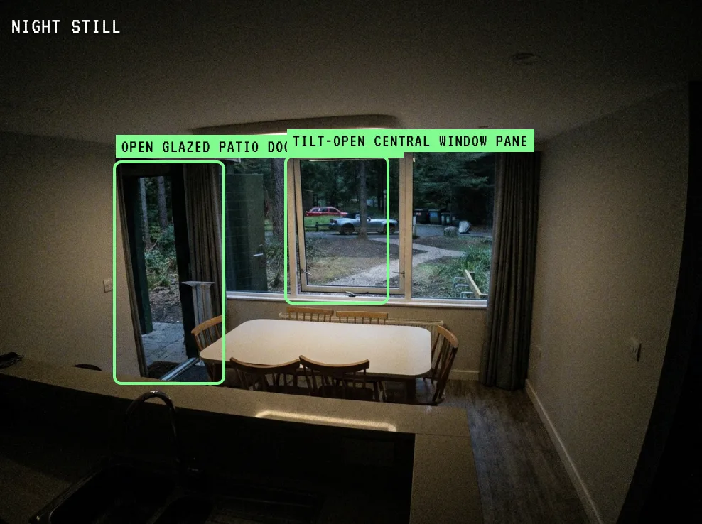 A dining room still with the open patio door and tilted window pane boxed in green and labelled